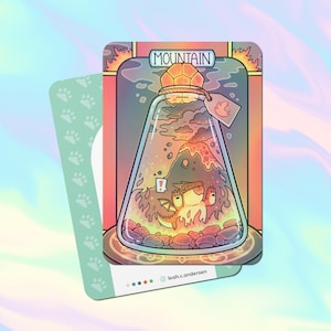 May include: A fantasy art card featuring a mountain scene inside a glass bottle. The card has a light green paw print design on the back. The bottle has a label that says "MOUNTAIN". The artist's name is at the bottom.