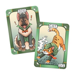 May include: Two illustrated playing cards with green borders and paw prints. The first card features a dog wearing a detective hat and a bow tie. The card is labelled "DOG". The second card features a cat wearing a detective hat and a red scarf. The card is labelled "CAT" and has the number "2/2" in the bottom right corner.
