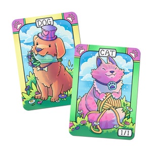 Peut inclure: Deux cartes à jouer illustrées représentant un chien et un chat. La carte du chien est rose et bleue avec un fond bleu clair et le texte "DOG". La carte du chat est verte et jaune avec un fond bleu clair et le texte "CAT".