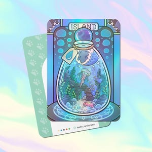 May include: A blue and green illustration of a glass bottle with a cork stopper. The bottle contains a miniature underwater scene with a jellyfish, seaweed, and a small crab. The bottle is labeled "Island".