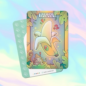 May include: A yellow banana with a brown stem and a monkey peeking out from behind it. The banana is surrounded by green leaves and has a +2 written on it. The text "BANANA" is written in a yellow box at the top of the card.
