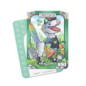 Op de afbeelding: Een cartoon dinosaurus kaart spel kaart met een regenboogkleurige staart en een zwart shirt met een regenboog hart. De kaart is groen met witte tekst die "Dinosaur" en "Trample 3/3" zegt.