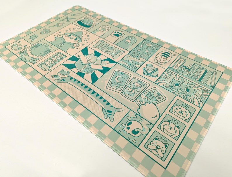 May include: A rectangular mat with a repeating checkerboard pattern in light beige and teal. The mat features a comic-style design with various cat illustrations, including a cat in a box, a long cat, and cats with magical elements.