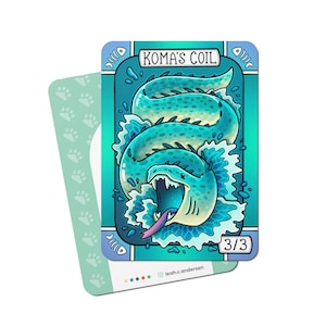 May include: A blue and green illustrated card with the text "KOMA'S COIL" and "3/3". The card features a cartoon image of a blue and green sea serpent with sharp teeth and a pink tongue.