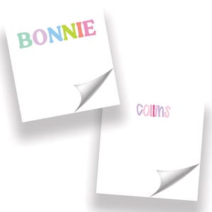 May include: Two square white sticky notes with curled bottom-right corners. The top note features the name BONNIE in multicolored block letters, while the bottom note displays the name COLLINS in a smaller, rounded, multicolored font.