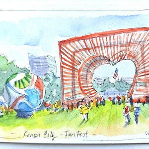 May include: A watercolor illustration of Kansas City FanFest featuring a large orange heart-shaped sculpture, a colorful spherical object, and a crowd of people on a green lawn. The text Kansas City - FanFest is written at the bottom.