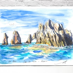 May include: Watercolor painting of the Los Cabos rock formations in Cabo San Lucas, Mexico. The artwork depicts the sea, sky, and rock formations in shades of blue, brown, and white. The text "Los Cabos - Cabo San Lucas - México" is visible.
