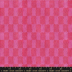 May include: Close-up of a pink fabric with a checkered pattern. The pattern alternates between solid pink squares and squares with a dotted texture in a slightly darker shade of pink. The fabric has a ruler at the bottom with the text "RUBY STAR SOCIETY".