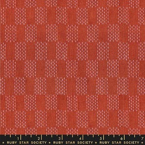 May include: Close-up of a fabric with a repeating pattern of orange squares with white dotted accents. The fabric has a textured appearance. The bottom of the image has the text "RUBY STAR SOCIETY".