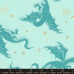 May include: A light blue fabric with a repeating pattern of teal dragons and gold starbursts. The dragons have detailed wings and long tails. The text "RUBY STAR SOCIETY" is at the bottom.