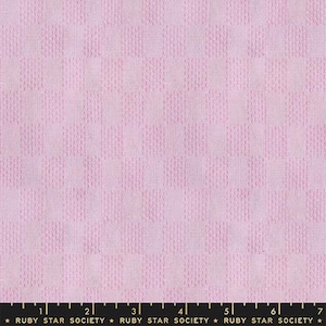 May include: A close-up of a light pink fabric with a textured, checkered pattern. The fabric has a grid-like design, with each square slightly raised. The bottom of the image shows a ruler with the text "RUBY STAR SOCIETY".