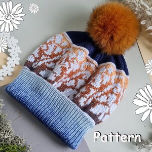 May include: A knitted winter hat with a blue and white pattern, topped with a large orange pom-pom. The hat has a blue brim that fades into a lighter blue. The word "Pattern" is visible on the bottom right.