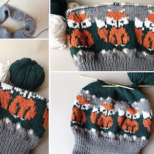 K&ouml;nnte beinhalten: Eine Strickm&uuml;tze im Entstehungsprozess mit einem sich wiederholenden Muster aus orangefarbenen F&uuml;chsen auf grauem und gr&uuml;nem Hintergrund. Stricknadeln und verschiedenfarbige Garne, darunter Wei&szlig; und Dunkelgr&uuml;n, sind zu sehen.