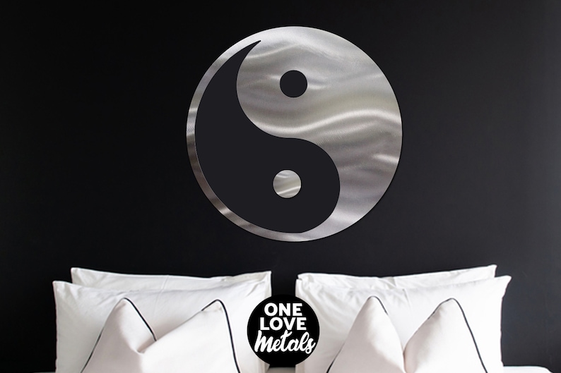 Peut inclure: Une d&eacute;coration murale en m&eacute;tal argent&eacute; repr&eacute;sentant le symbole yin yang avec une finition bross&eacute;e. Le symbole est suspendu &agrave; un mur noir au-dessus d'un lit blanc avec des oreillers blancs. Le texte "ONE LOVE metals" est visible en bas au centre de l'image.