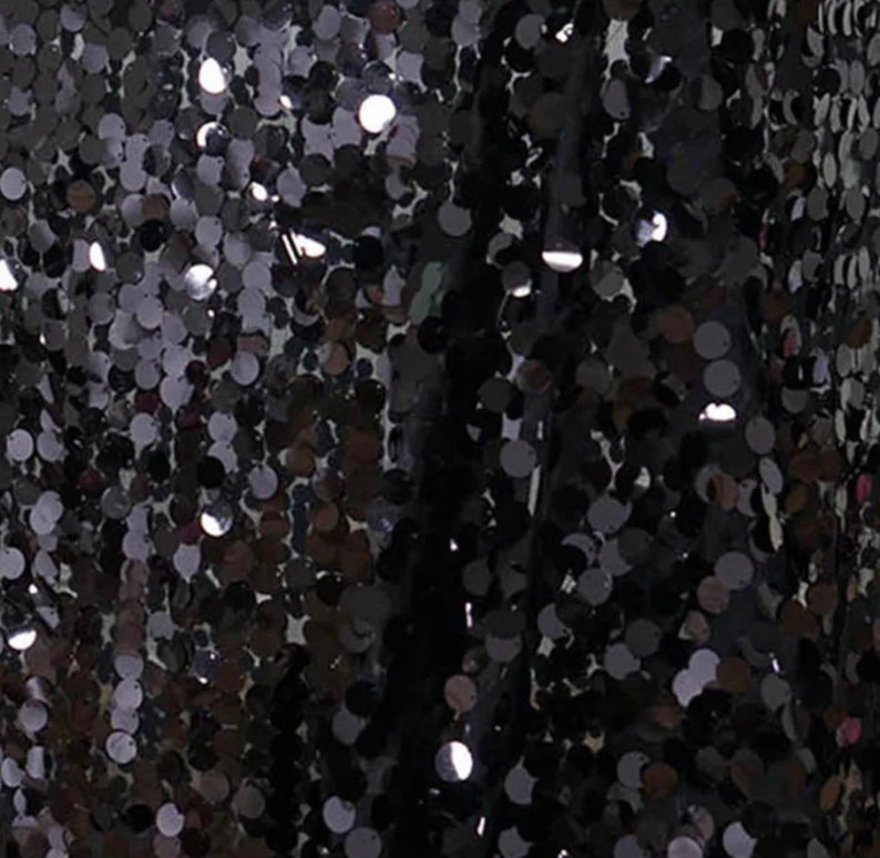 May include: Black fabric with a pattern of small, round sequins.