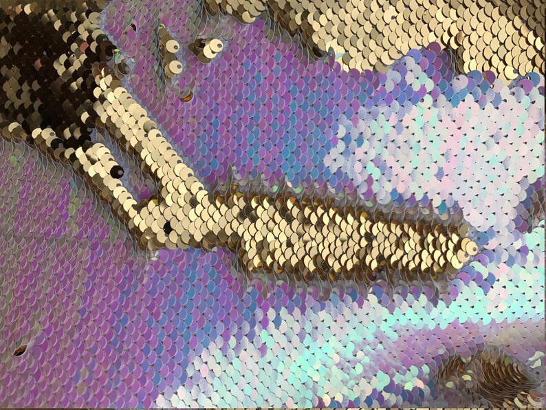 May include: Close-up of iridescent purple, blue, and white sequins with a gold sequin stripe.