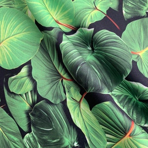 May include: A close-up of a fabric with a tropical leaf print. The leaves are a deep green color and are arranged in a random pattern on a black background.