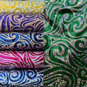 May include: Four rolls of iridescent fabric with a swirl pattern. The fabric is available in yellow, purple, pink, and blue.