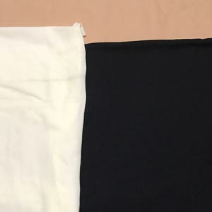May include: A close-up of two fabric swatches. One swatch is white and the other is black.