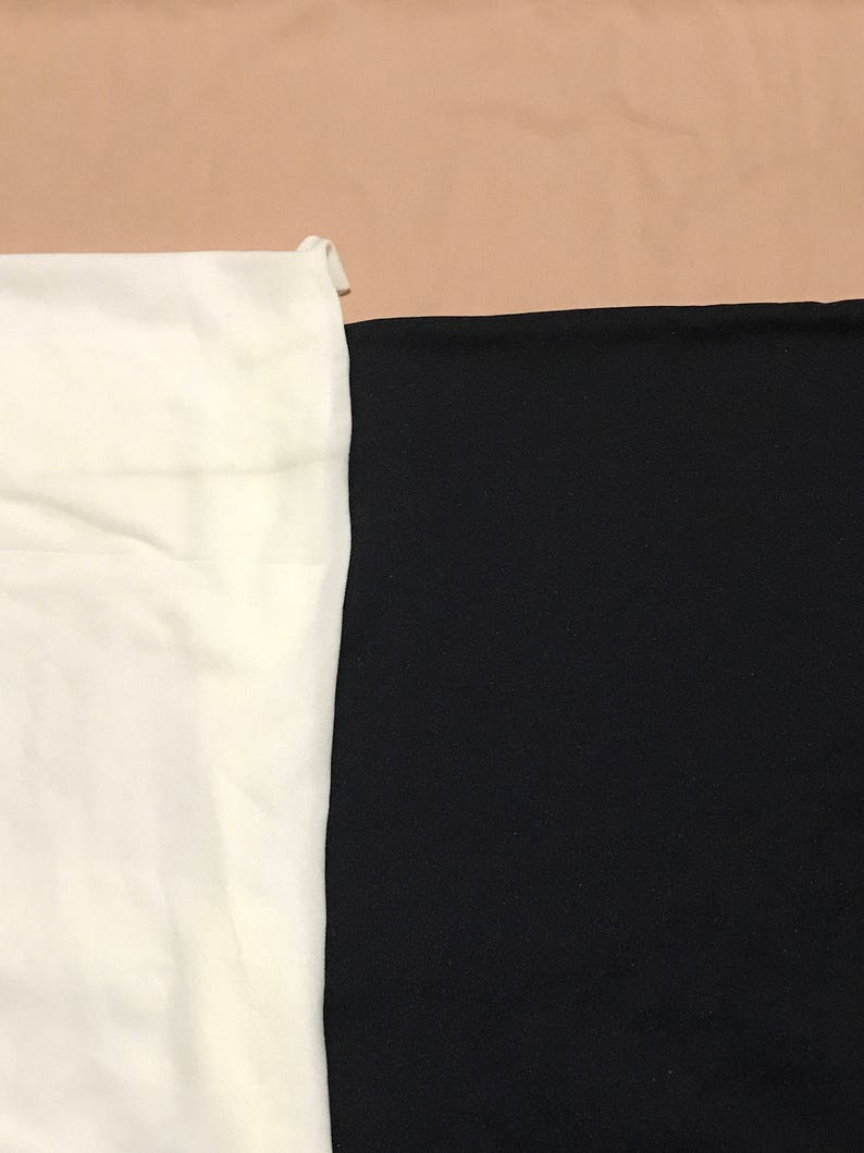 May include: A close-up of two fabric swatches. One swatch is white and the other is black.