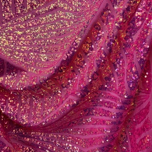 Puede incluir: Tela rosa con lentejuelas iridiscentes en un patrón geométrico.