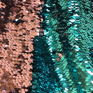 Puede incluir: Primer plano de una tela con dos secciones distintas. Un lado presenta lentejuelas de color cobre, mientras que el otro muestra lentejuelas de color turquesa. Las lentejuelas est&aacute;n dispuestas en un patr&oacute;n de escamas, creando una superficie texturizada. Esta tela es adecuada para proyectos de costura.