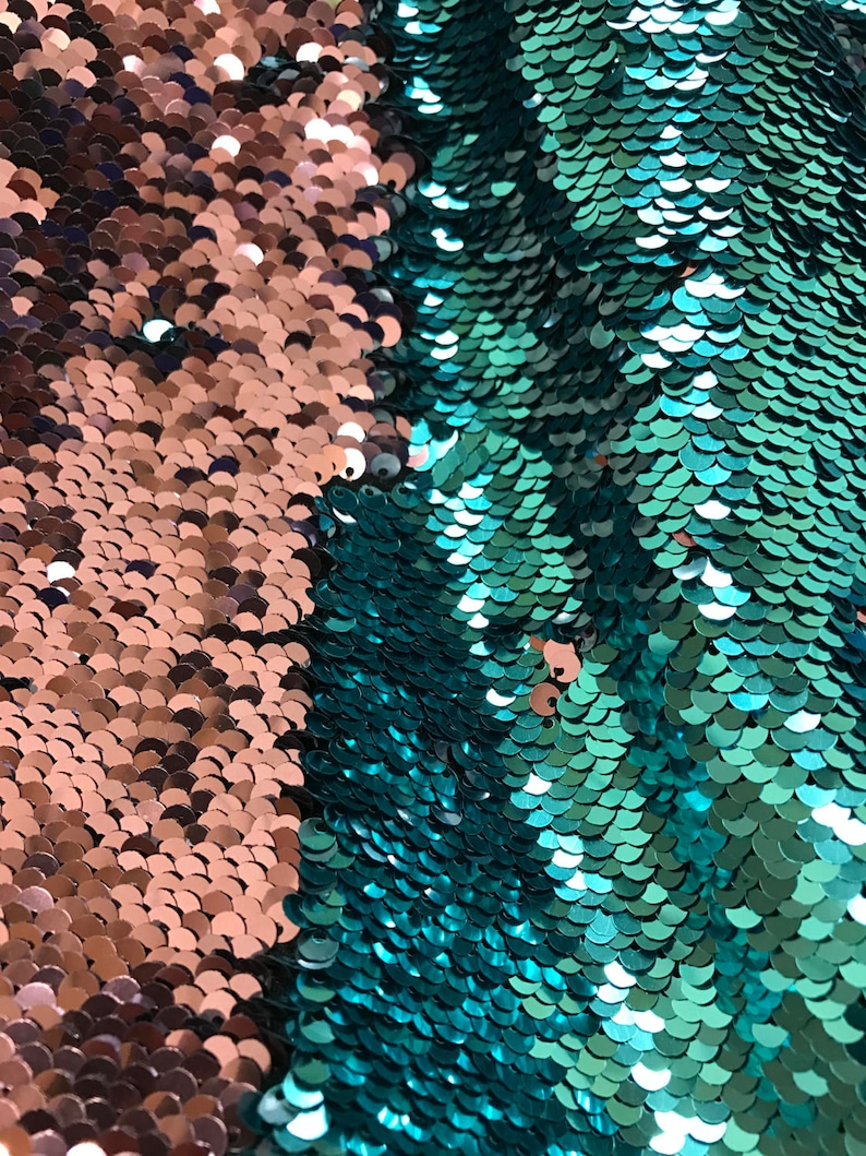 Puede incluir: Primer plano de una tela con dos secciones distintas. Un lado presenta lentejuelas de color cobre, mientras que el otro muestra lentejuelas de color turquesa. Las lentejuelas est&aacute;n dispuestas en un patr&oacute;n de escamas, creando una superficie texturizada. Esta tela es adecuada para proyectos de costura.