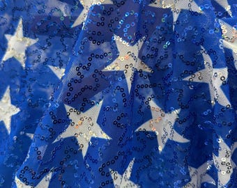 Nuevas lentejuelas. Estampado de estrellas blancas y base azul sobre tela de malla. Elástico en 4 direcciones. 152 cm de ancho. Se vende cortado a medida.