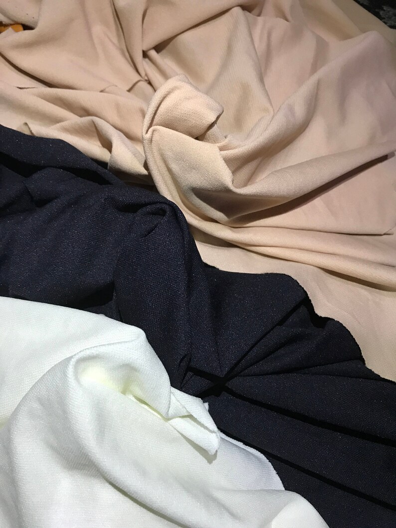 May include: Three fabric swatches in different colors: beige, black, and white. The fabric is soft and has a slight texture.