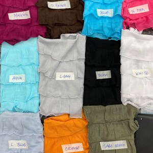 K&ouml;nnte beinhalten: Zehn Stoffmuster in verschiedenen Farben und Texturen, darunter Magenta, Braun, Blau, Rosa, Aqua, Hellgrau, Schwarz, Wei&szlig;, Hellblau, Orange und Salbeigr&uuml;n. Jedes Muster ist mit dem Farbnamen beschriftet.