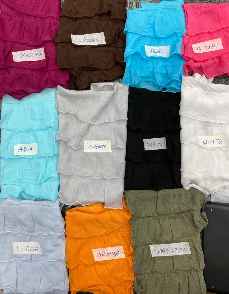 K&ouml;nnte beinhalten: Zehn Stoffmuster in verschiedenen Farben und Texturen, darunter Magenta, Braun, Blau, Rosa, Aqua, Hellgrau, Schwarz, Wei&szlig;, Hellblau, Orange und Salbeigr&uuml;n. Jedes Muster ist mit dem Farbnamen beschriftet.