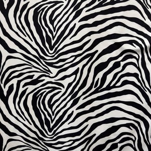 May include: Black and white zebra print fabric with a swirling pattern.