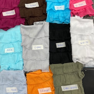 K&ouml;nnte beinhalten: Eine Sammlung von 12 Stoffproben in verschiedenen Farben, darunter Magenta, Braun, Blau, Rosa, Aqua, Hellgrau, Schwarz, Wei&szlig;, Hellblau, Orange und Salbeigr&uuml;n. Jede Probe ist mit einem Etikett mit dem Farbnamen versehen.
