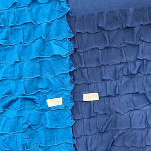 K&ouml;nnte beinhalten: Zwei Stoffproben, eine in Teal und eine in Marineblau, mit einer gekr&auml;uselten Textur. Die Proben sind mit "Teal" und "Navy" beschriftet.