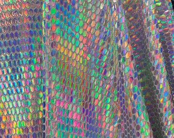 以下が含まれることがあります： 六角形の模様が施された虹色の生地のクローズアップ。生地は銀色のベースに虹色の光沢があります。