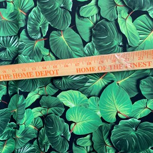May include: Green tropical leaf print fabric with a black background. The fabric is measured with a ruler that reads "THE HOME DEPOT" and "HOME OF THE FINEST".
