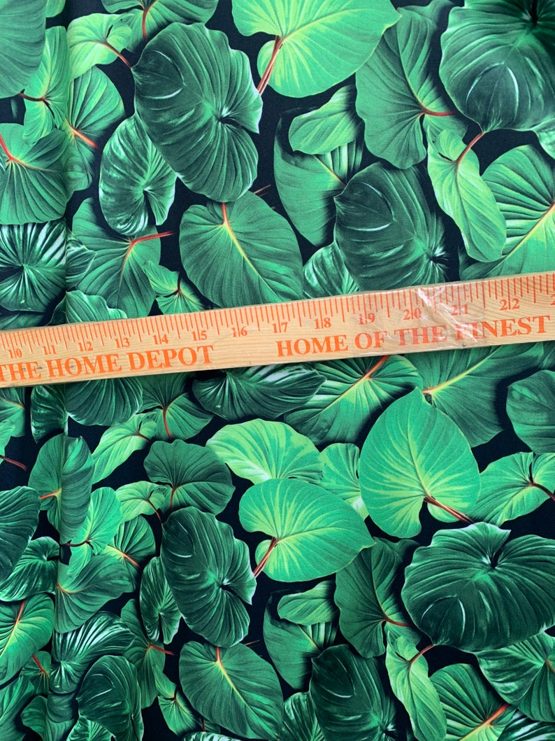 May include: Green tropical leaf print fabric with a black background. The fabric is measured with a ruler that reads "THE HOME DEPOT" and "HOME OF THE FINEST".