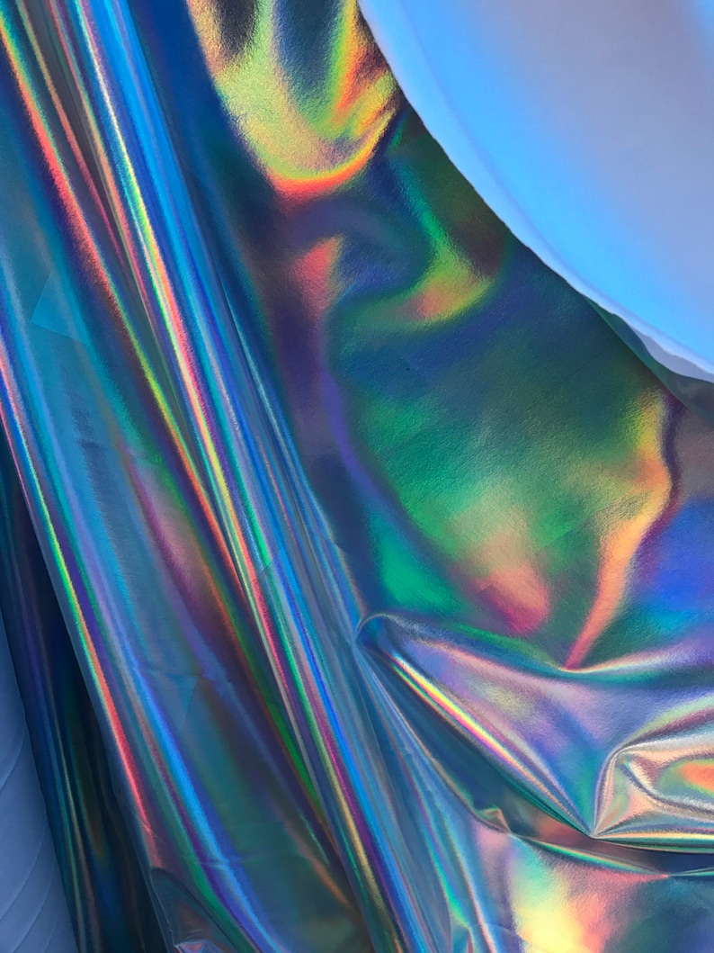 May include: A close-up of iridescent fabric with a blue, green, and purple colour scheme. The fabric is folded and has a smooth, shiny surface.