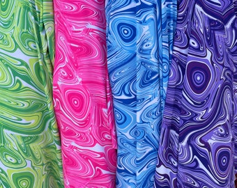 May include: Three fabric swatches with a swirling, marbled pattern. The swatches are green, pink, and purple.