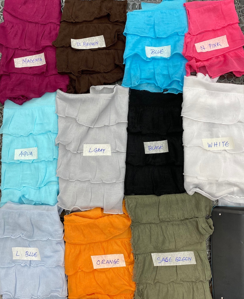 K&ouml;nnte beinhalten: Zehn Stoffmuster in verschiedenen Farben und Texturen, jedes mit einem Etikett, das die Farbe identifiziert. Die Farben sind: Magenta, Dunkelbraun, Blau, Hellrosa, Aqua, Hellgrau, Schwarz, Wei&szlig;, Hellblau, Orange und Salbeigr&uuml;n.