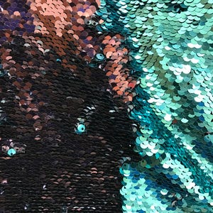 Puede incluir: Primer plano de una tela cubierta de lentejuelas iridiscentes. Las lentejuelas cambian de color de negro a verde azulado y cobre. La textura es suave y reflectante, creando un efecto brillante. Las lentejuelas est&aacute;n dispuestas en un patr&oacute;n denso.