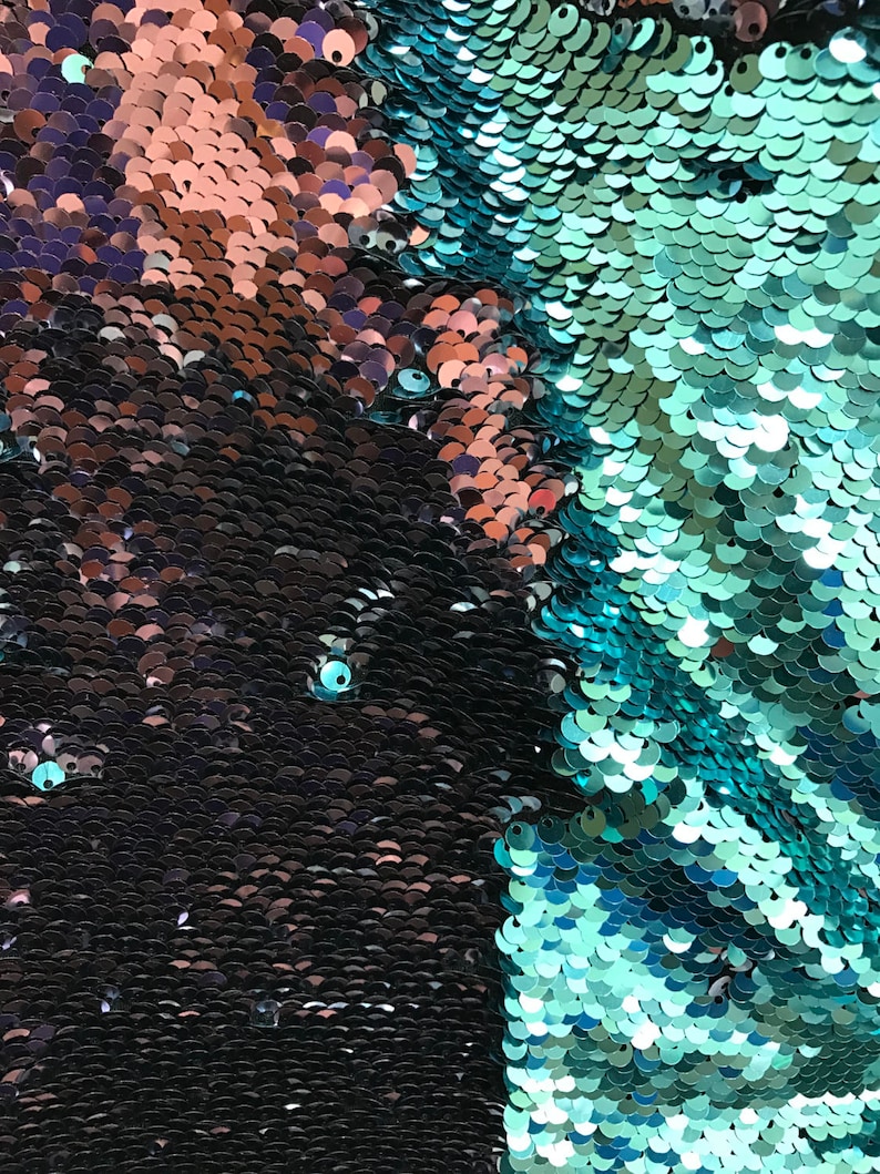 Puede incluir: Primer plano de una tela cubierta de lentejuelas iridiscentes. Las lentejuelas cambian de color de negro a verde azulado y cobre. La textura es suave y reflectante, creando un efecto brillante. Las lentejuelas est&aacute;n dispuestas en un patr&oacute;n denso.