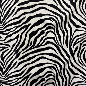 May include: Black and white zebra print fabric with a wavy pattern.