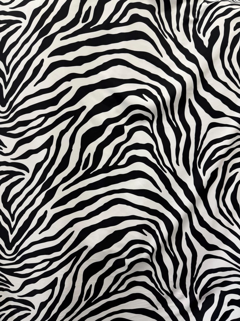 May include: Black and white zebra print fabric with a wavy pattern.