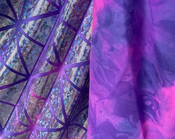 May include: Two fabric samples. One is a shiny, iridescent purple with a geometric web-like pattern. The other is a tie-dye fabric with shades of purple and pink, creating a swirling effect. Both fabrics are folded.