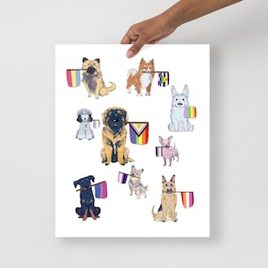 May include: A print featuring watercolor illustrations of various dog breeds, each holding a Pride flag in their mouths. The dogs are in different poses and colors, with flags representing different LGBTQ+ identities. The print is held by a person.