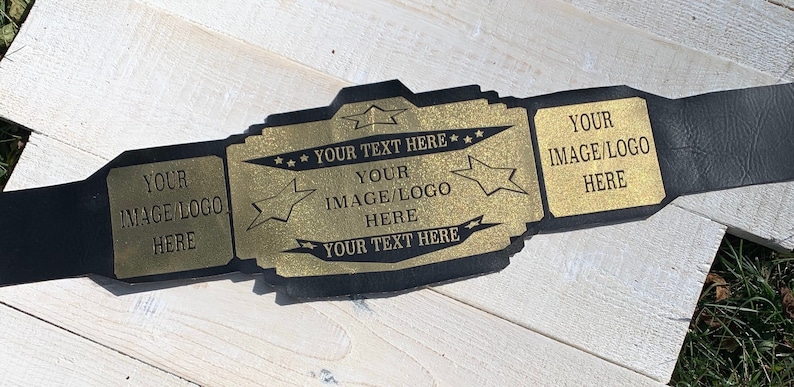 May include: A gold-coloured championship belt with black straps. The belt has three plates with the text "YOUR IMAGE/LOGO HERE" and "YOUR TEXT HERE" on each plate. The plates are decorated with stars.