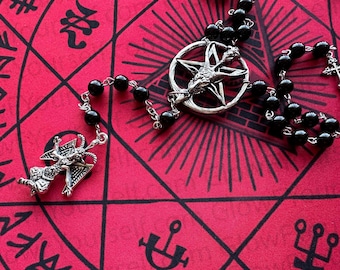 Può includere: Una collana in stile rosario con perline nere lucide collegate da catene in metallo color argento. Il pezzo centrale è un ciondolo circolare con una testa di capra all'interno di un pentagramma e un ciondolo a forma di Baphomet pende dall'estremità.