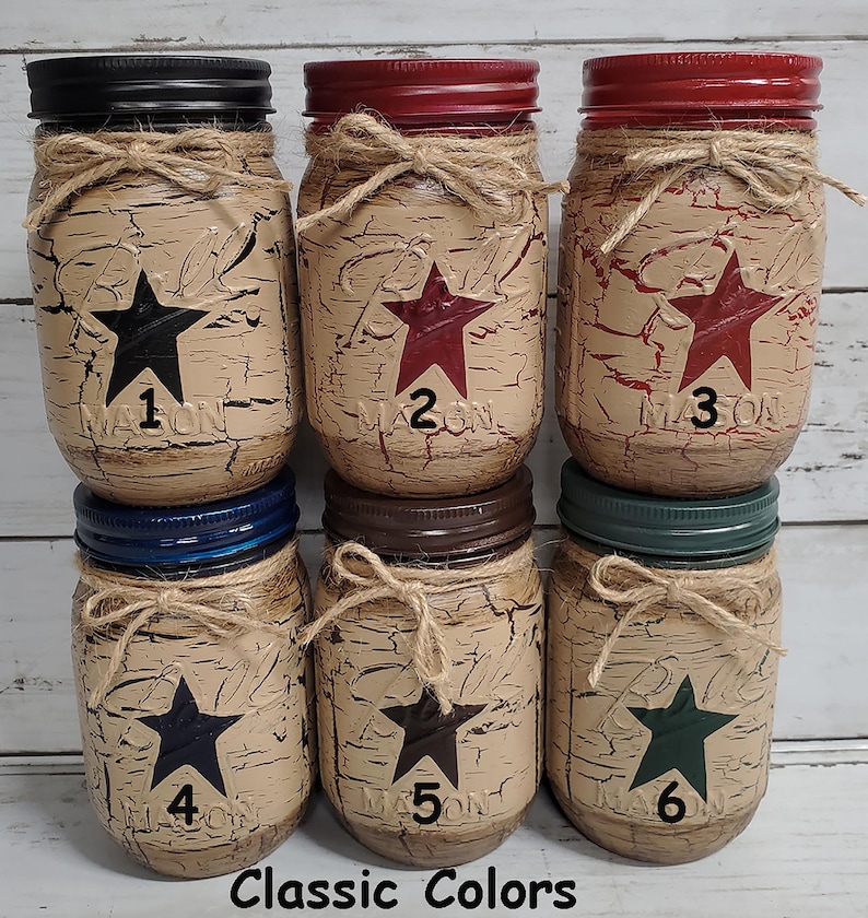 May include: Six mason jars with distressed paint and a star design in different colors. The jars are labeled with numbers 1 through 6. Classic Colors.