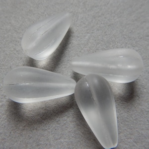 May include: Four clear glass teardrop beads with a frosted finish.